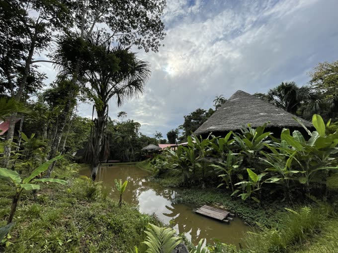 Una maloca de techo de palma junto a una laguna, en la Amazonía peruana